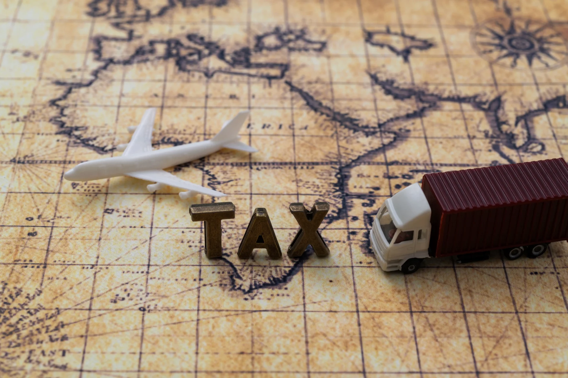 Airplane, truck, "tax" on vintage map background.