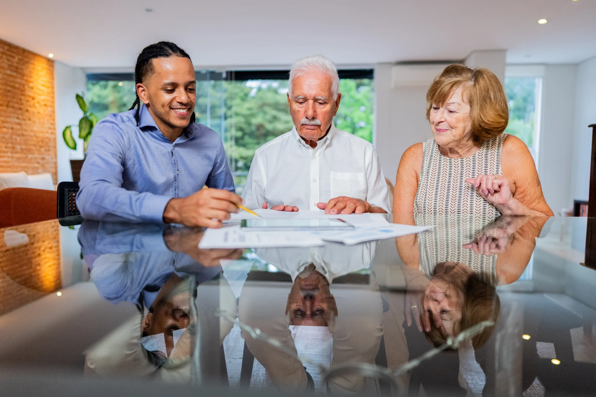 Three people reviewing documents at table.