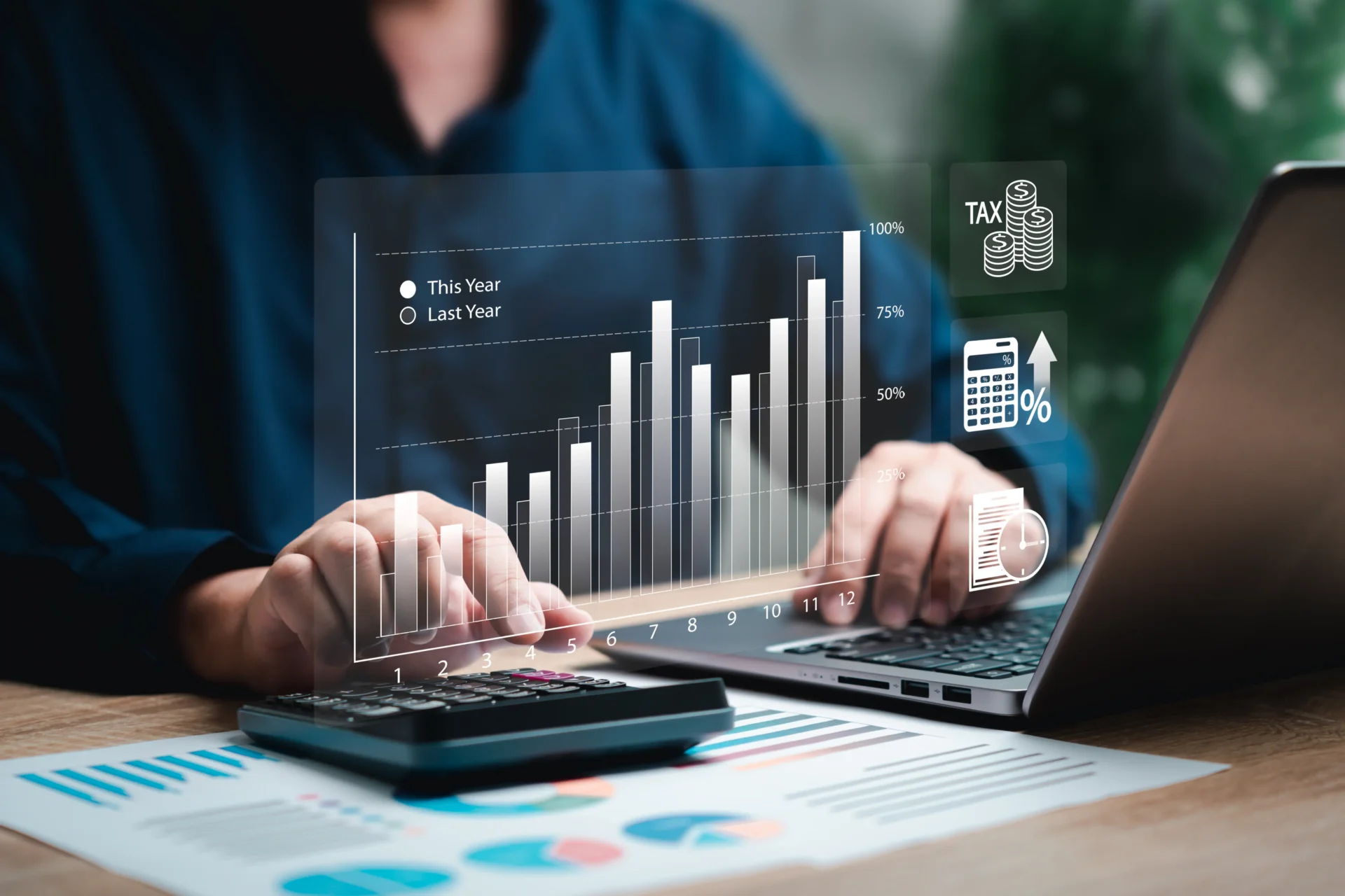 Business analysis with laptop and financial charts.